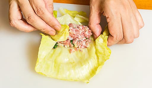 調理工程04_キャベツの葉に混ぜた豚ひき肉を乗せ、巻いていく